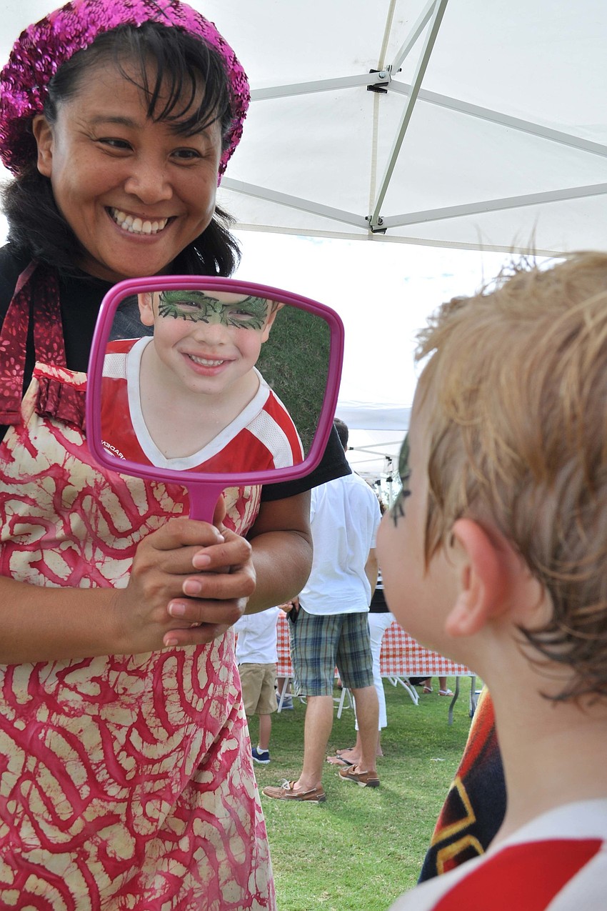 Akiko Campbell shows Weston Hermann, 6,  the design she painted on his face.