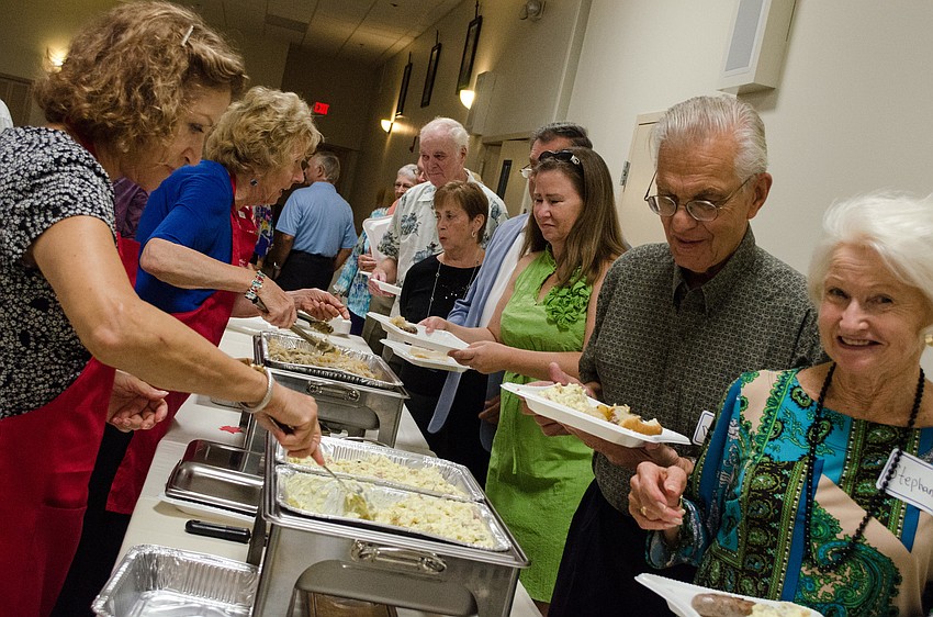 Parish members are served brats, sauerkraut, and potato salad for the Oktoberfest themed dinner.