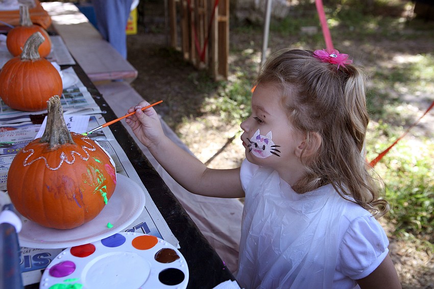 Gianna Grimaldi, 2, paints a pumpkin Saturday, Oct. 20, at the Fruitville Grove Pumpkin Festival.