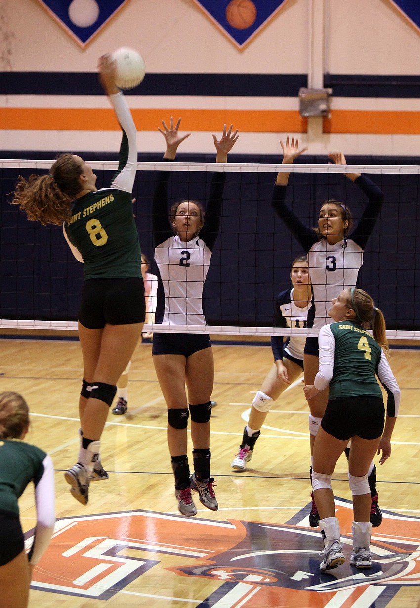 Tori Biach, No. 8, hits the ball as Hailey Preininger, No. 2, and Gabriella Costa, No. 3, prepare to block Biachâ€™s shot.