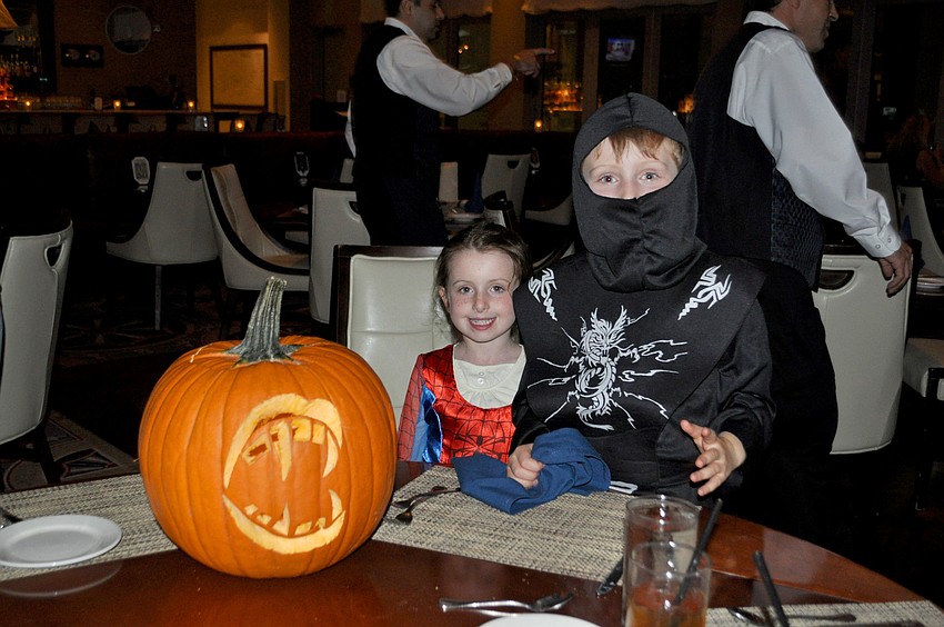 Young guests Katherine and George sit with their contest-winning pumpkin.