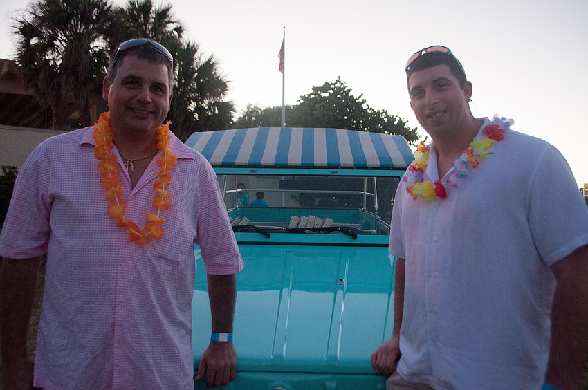 Tony Aveni and son Chris Aveni pose in front of their Surf Side Free Ride vintage Volkswagen vehicle.