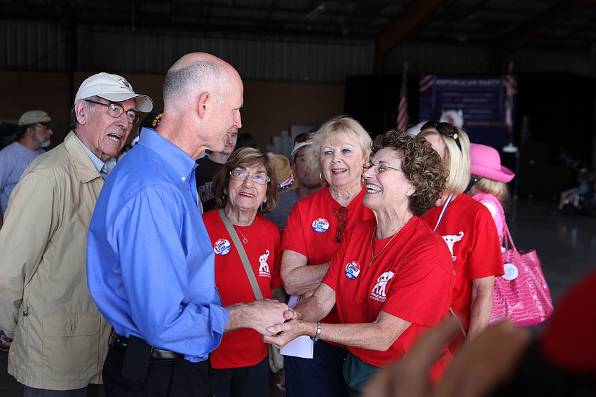 Gov. Rick Scott talks with volunteers prior to the start of the rally Saturday, Nov. 3, at Dolphin Aviation.