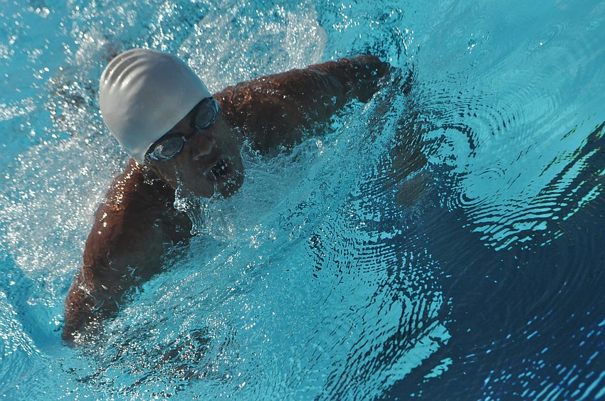 John Krueger competes in the boys 100-yard breaststroke.