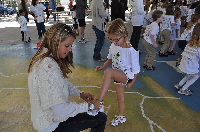 Brooke Hann helps her daughter, Saylor, tie her shoes.