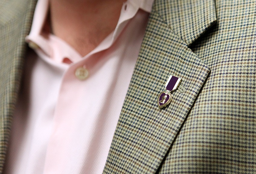 Corporal Michael Jernigan, USMC, Ret. wears a Purple Heart pin on his jacket.