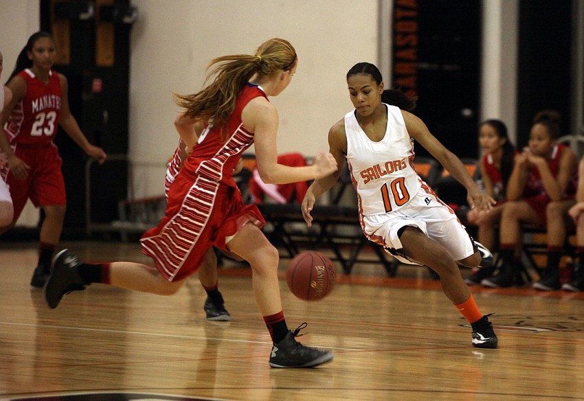 Manateeâ€™s Brittney Hartwig, No. 5, tries to block Sarasotaâ€™s Natasha Wilcox, No. 10, from getting down the court with the ball.