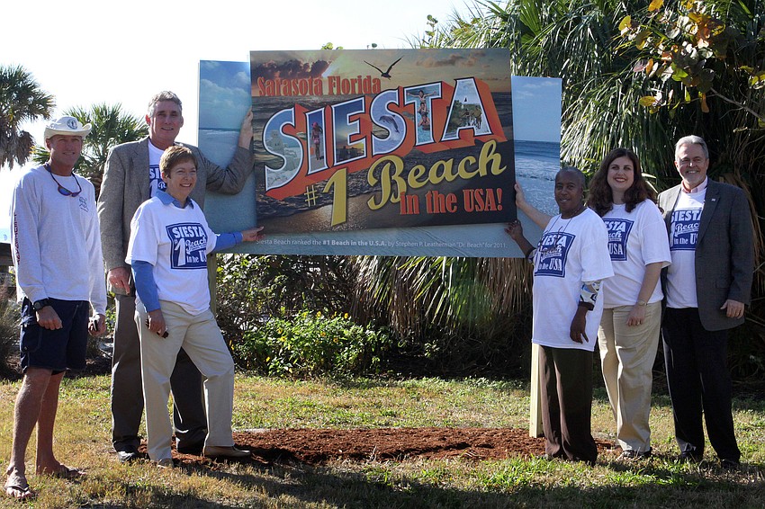 Lifeguard Scott Ruberg and County Commissioners Jon Thaxton, Nora Patterson, Carolyn Mason, Christine Robinson and Joe Barbetta unveil the welcoming Siesta Public Beach sign Jan. 18 to recognize the beachâ€™s status as No. 1 in the nation.