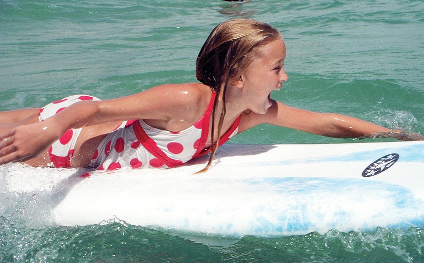 Haley Gillis paddles out to catch a wave Sunday, July 15, at Eternal Summer Surf Camp on Anna Maria Island