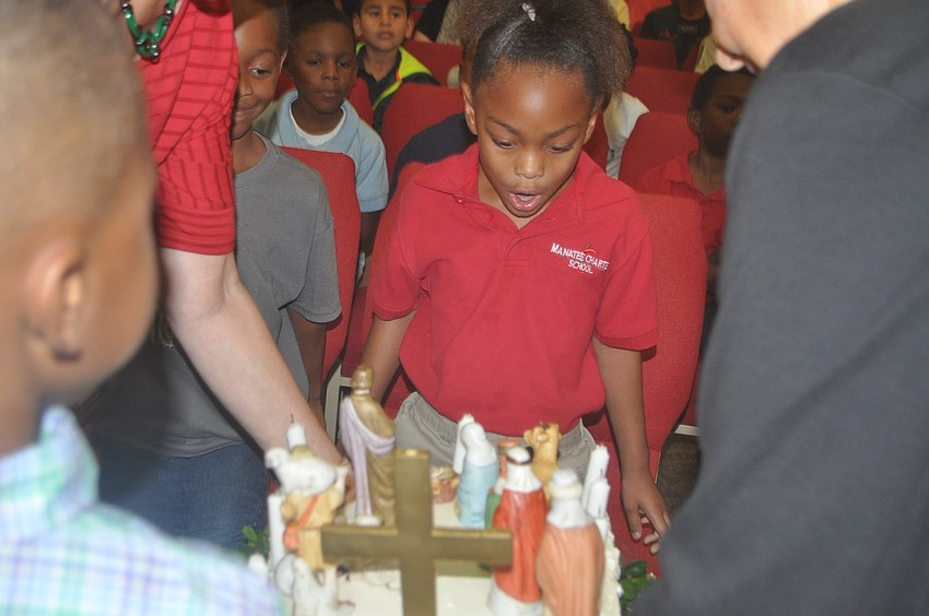 Amariah Miller blows out the candles on Jesusâ€™ birthday cake.