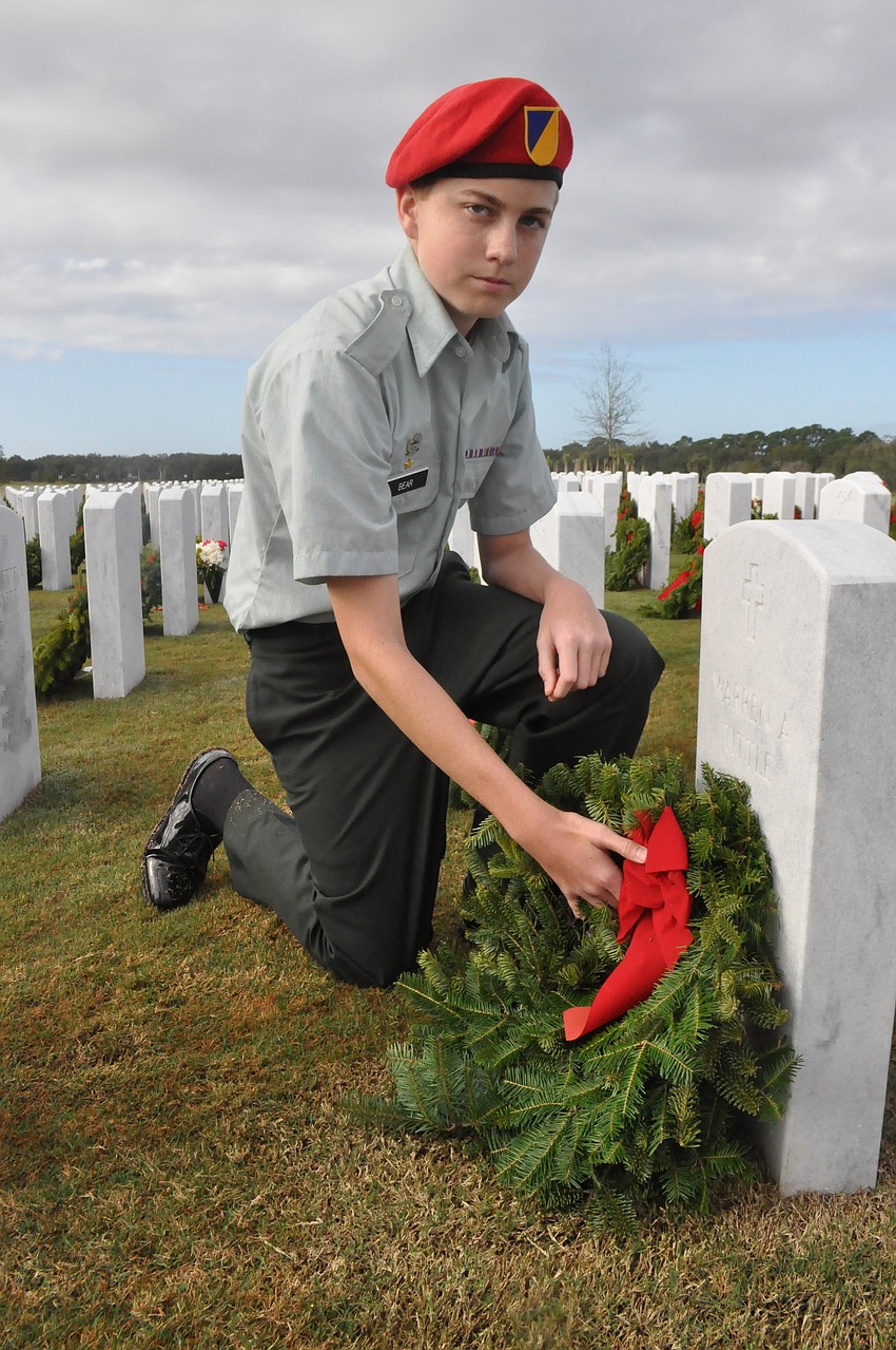 Taylor Bear, 15, a student at Sarasota Military Academy puts a wreath on his grandfatherâ€™s grave.