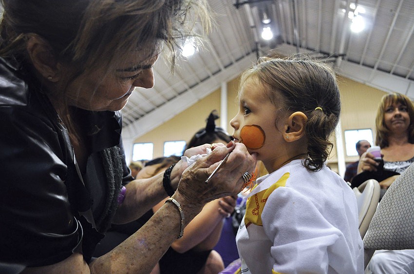 Marge Wallick puts the finishing touches on the face of Aleigha Quiroz, 2, during the YMCA's Family Fall Festival Oct. 19. Published Oct. 25, 2012.