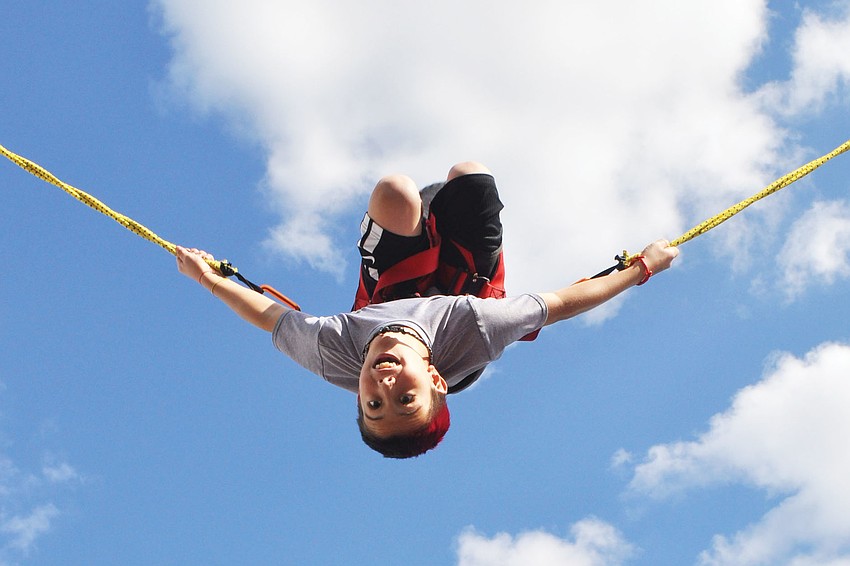 Connor Losada soars on the bungee jump, at the Tara Elementary Fall Festival. Published Nov. 22, 2012.