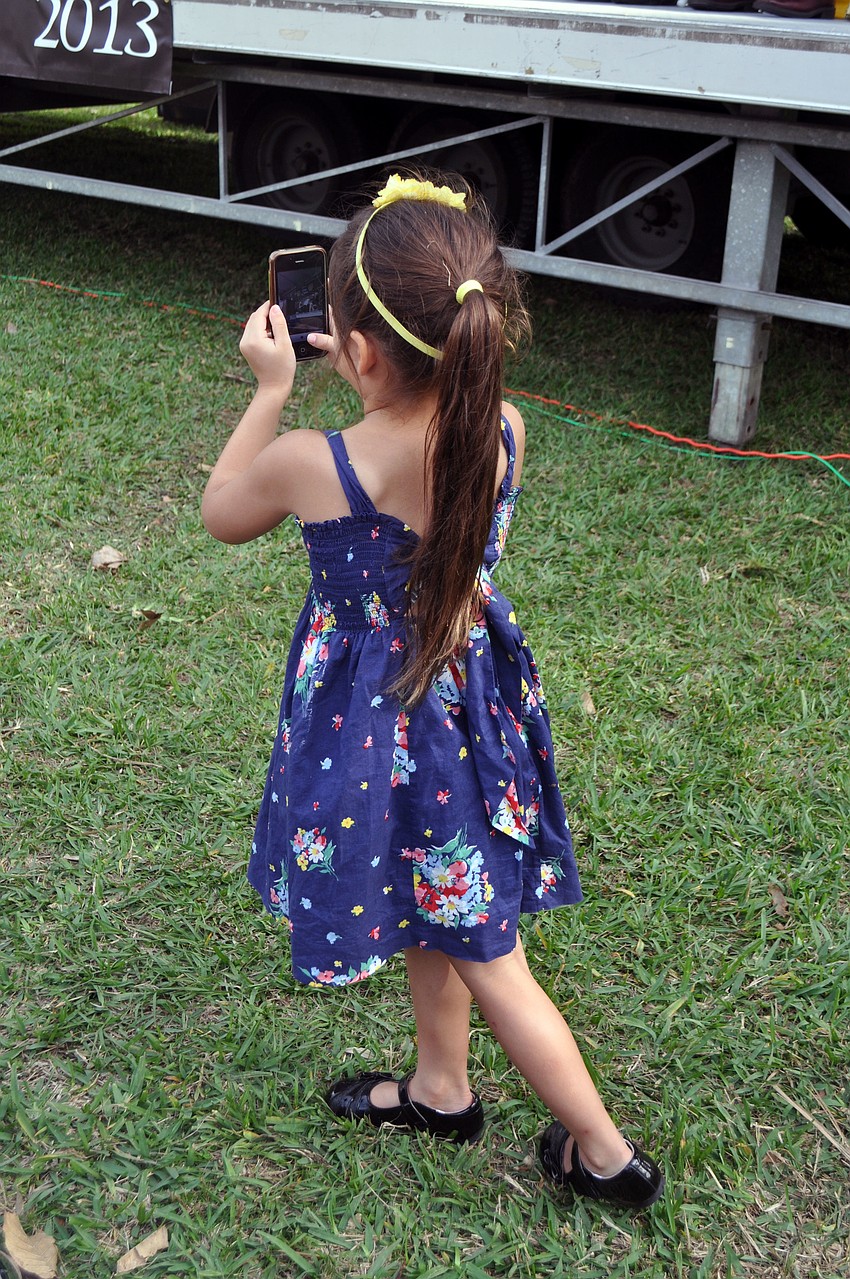 Siani Quiros snaps an iPhone photo of her great-uncle, Pablo Rodriguez, during the induction ceremony.
