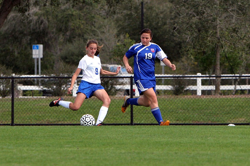 Sarasota Christianâ€™s Taylor Smith, No. 9, kicks the ball down the field for a pass as Northside Christianâ€™s Sydnee Burtzlaff, No. 19, tries to block the pass.
