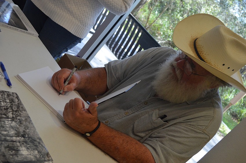 Photographer Clyde Butcher signs his book for those who attended the conference.