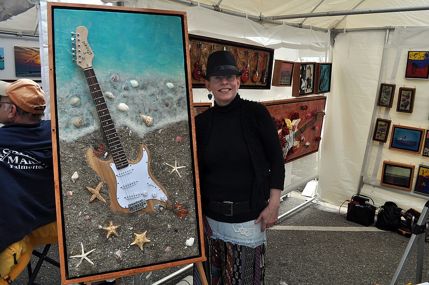Jennifer Martin of Mi Corazon Art poses with one of her pieces entitled â€œBeach Guitarâ€.