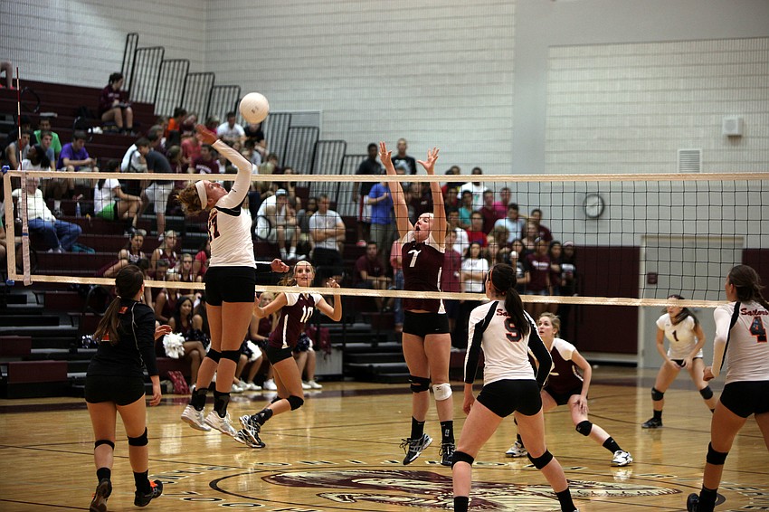 Genevieve Rowe, No. 17, prepares to spike the ball over the net as Carly Scarbrough, No. 7, gets ready to try and block the ball.
