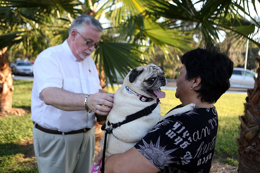 Deacon Tom Grant blesses Mary Seguerraâ€™s dog, Pugley, 2, Friday, Sept. 28 during the pet blessing ceremony.