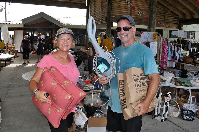 Mary Harper and Randy Mikkelson walked away from the Sarasota Sailing Squadronâ€™s garage sale with a variety items including pillows and vacuum cleaner.
