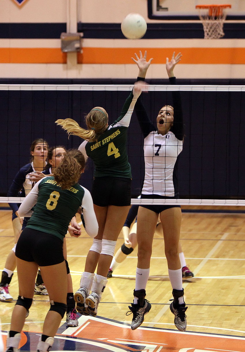 Gabriella Woodruff, No. 4, gets the ball over the net and Emily Greenwood, No. 7, attempts to block Woodruffâ€™s shot.