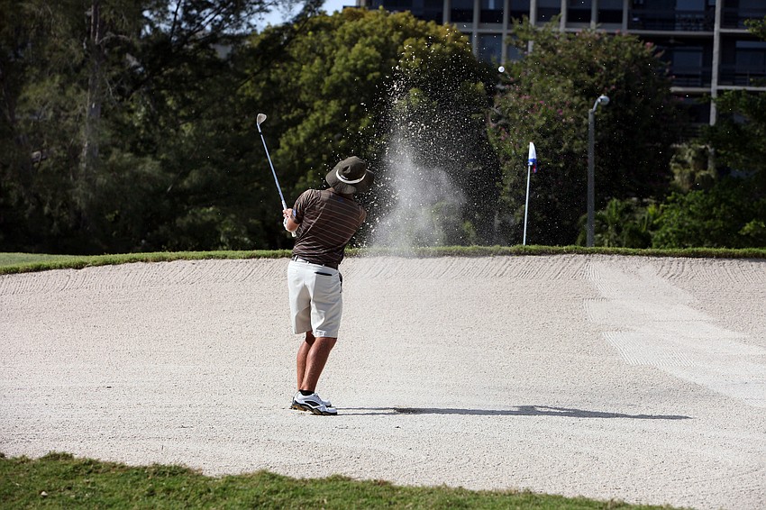 Jhared Hack hits his ball out of a sand trap.