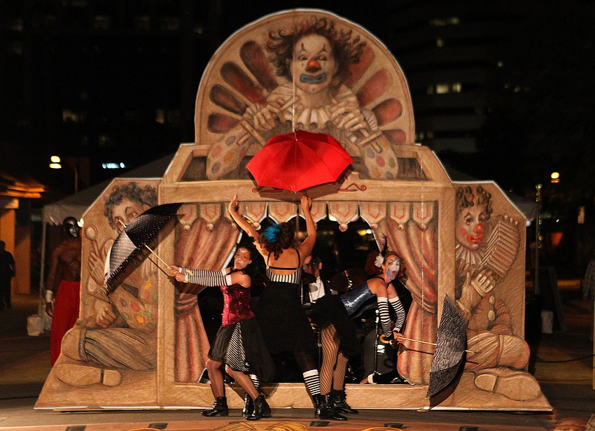 Aleah Alia, Anna Maria Diamont and Ashley Hassler perform with umbrellas during â€œ3-DANCEâ€ performed by Fuzion Dance Monday, Nov. 5, on Kurt Wennerâ€™s chalk piece.