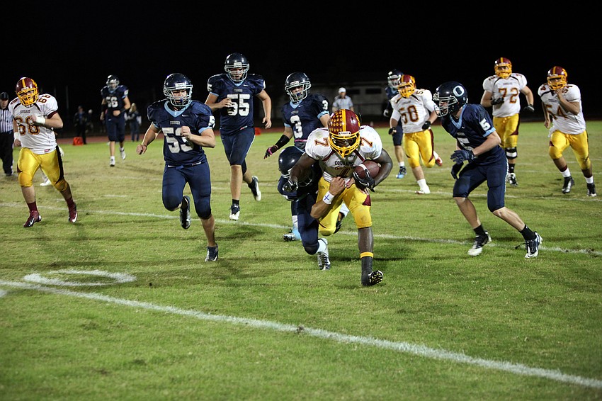 Demardre Patterson, No. 7, keeps going as JT Fischer, No. 3, tries to bring him down.