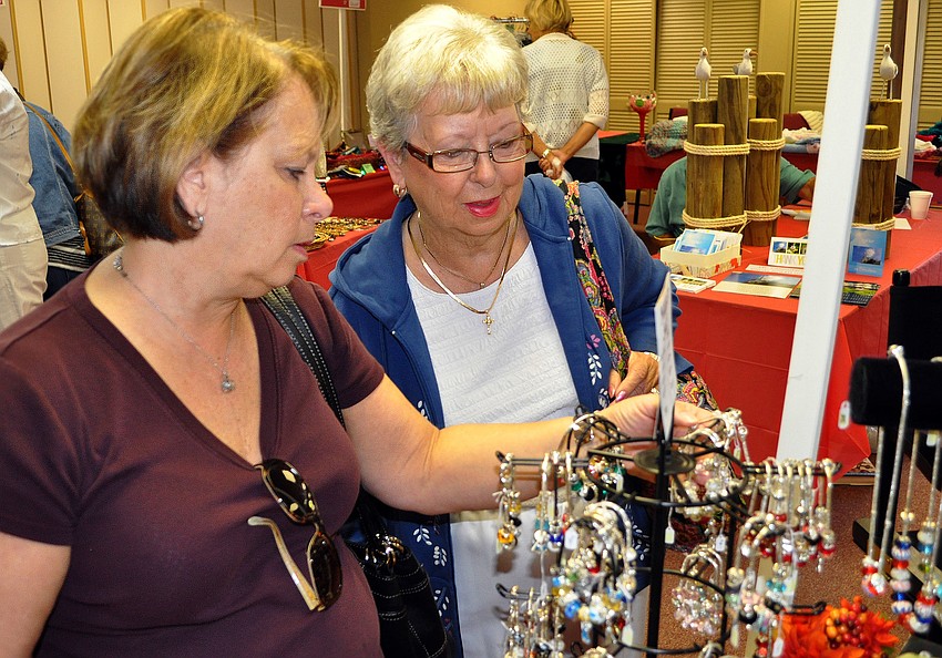 Terri McGuire and Ellen Ihle look at some items at the Longboat Key Island Chapel Holiday Bazaar.