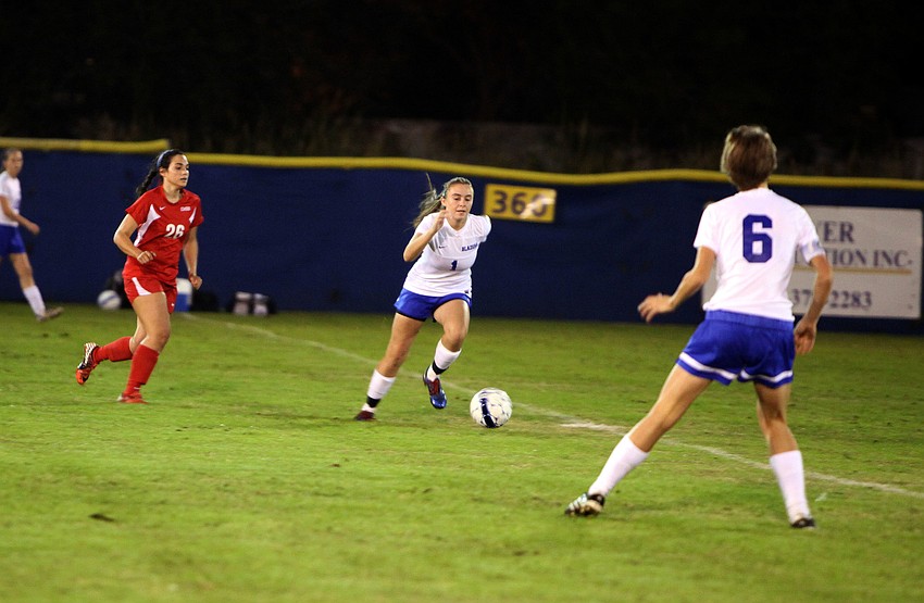 Sarasota Christianâ€™s Anna Cecelia Genson, No. 1, runs with the ball while Cardinal Mooneyâ€™s Gabby Ojeda, No. 26, tries to catch up with her.