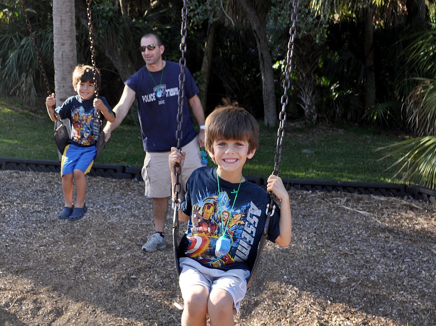 Darren Saltzberg pushes his sons, Josh and Jake, on the swings.