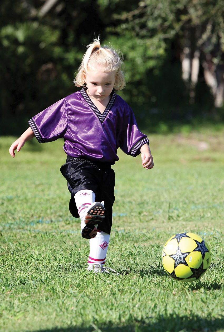Lily Wicks, 3, practices kicking the ball at her first soccer game Sept. 8, at Glebe Park for the first weekend of the Suncoast Sports Club season.