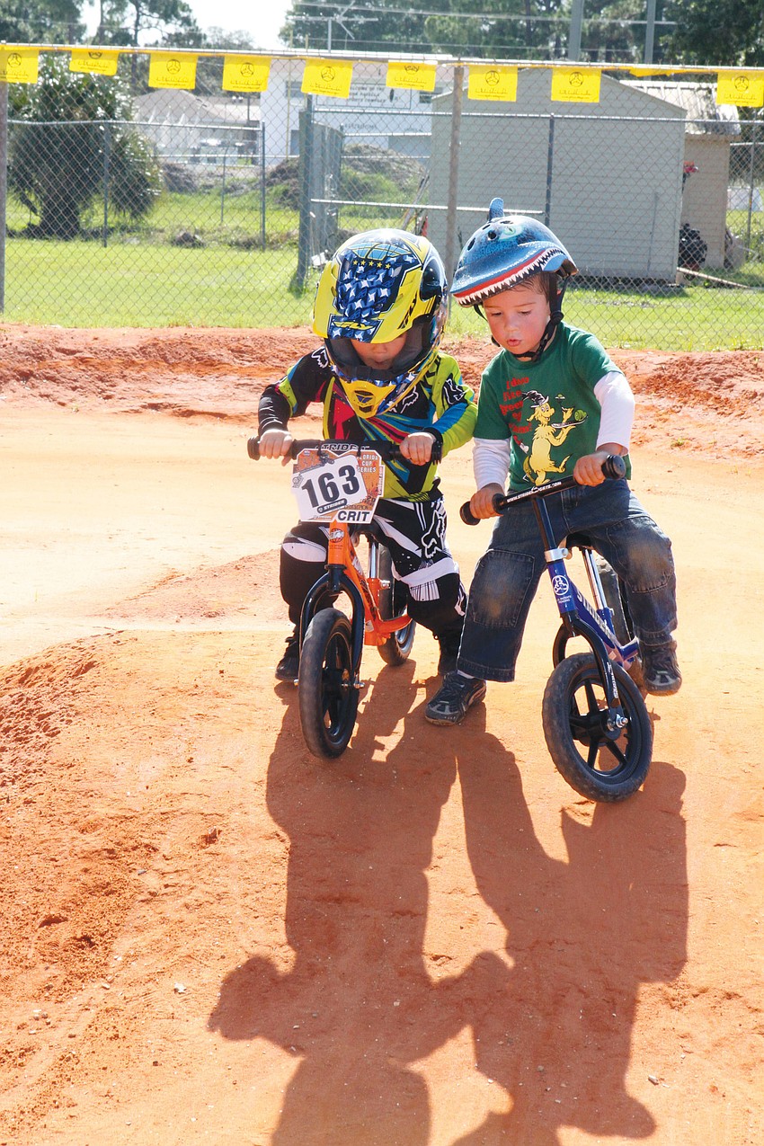 Wyatt Forsyth, 3, and Liam Keltch, 2, try to make their way down a hill on the Strider practice course at the Sarasota BMX Olympic Day.