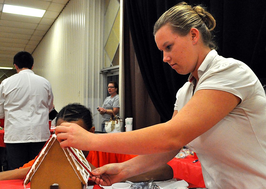 Samantha Lockhart, 16, adds twizzlers to the roof of Southeast High Schoolâ€™s gingerbread house.