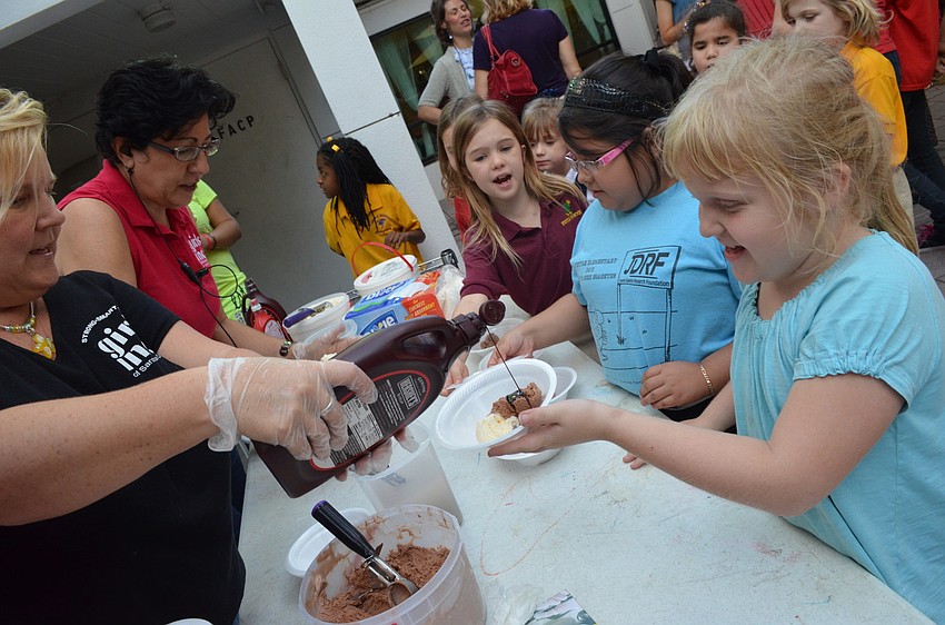 Lili Burrow gets chocolate syrup on her ice cream.