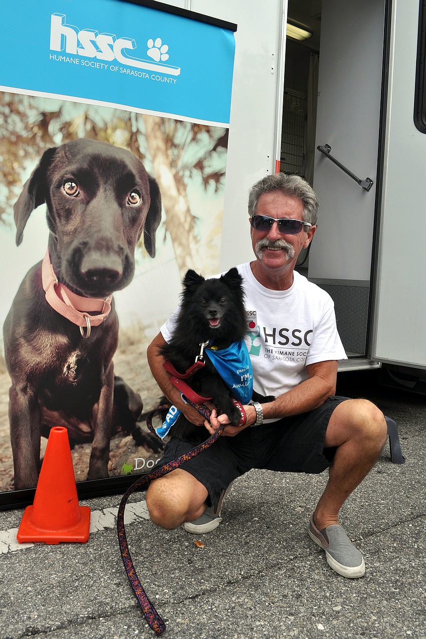 John McGurk holds Zippy, a 3-year-old black, Pomeranian, who is up for adoption.