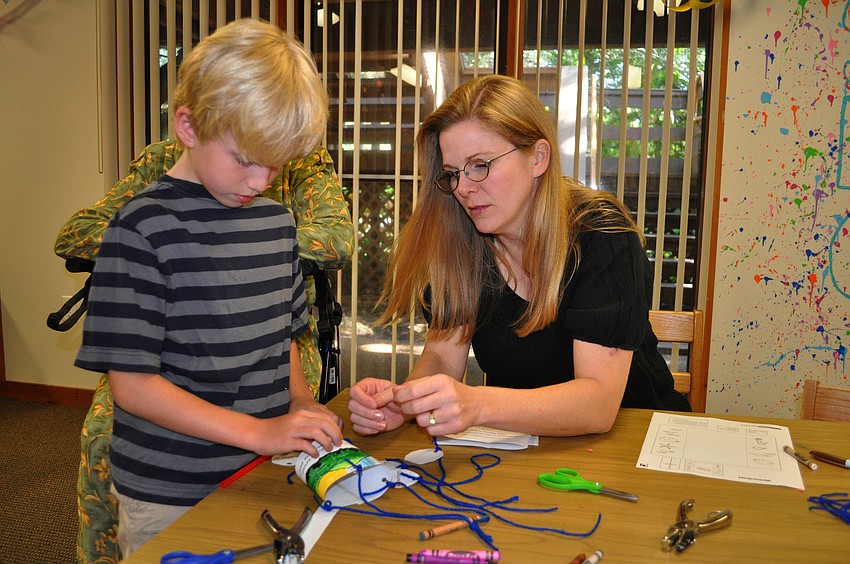 Caden Parker, 8, gets some assistance from his mom, Amy, as his finishes up his ChapelKidz project Sunday, Sept. 23 at Siesta Key Chapel.