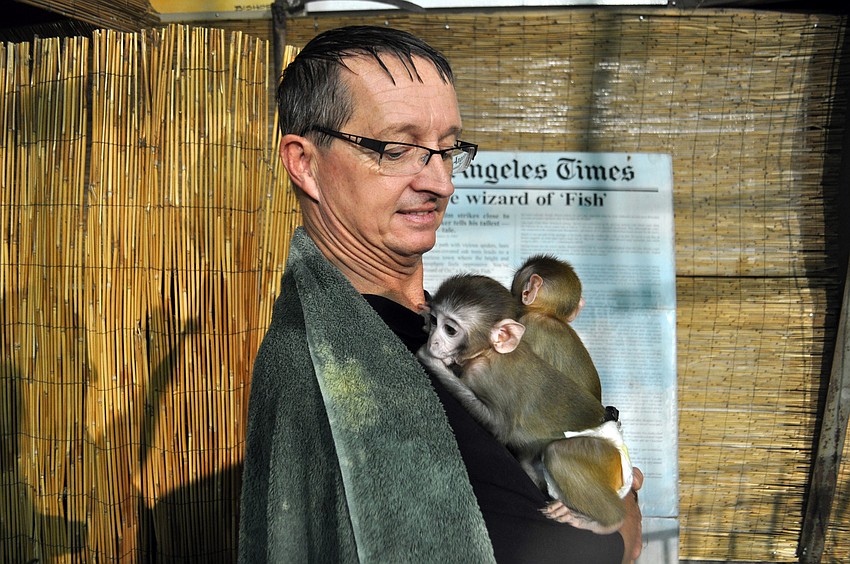 Dr. Rick Piatt poses with two monkeys.