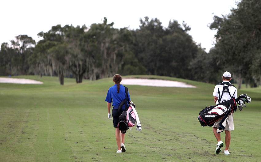 Victoria Johnson, 15, of Sarasota Military Academy, and Christopher Pollan, 15, of St. Stephenâ€™s, chat as they walk the course Tuesday, Oct. 9.