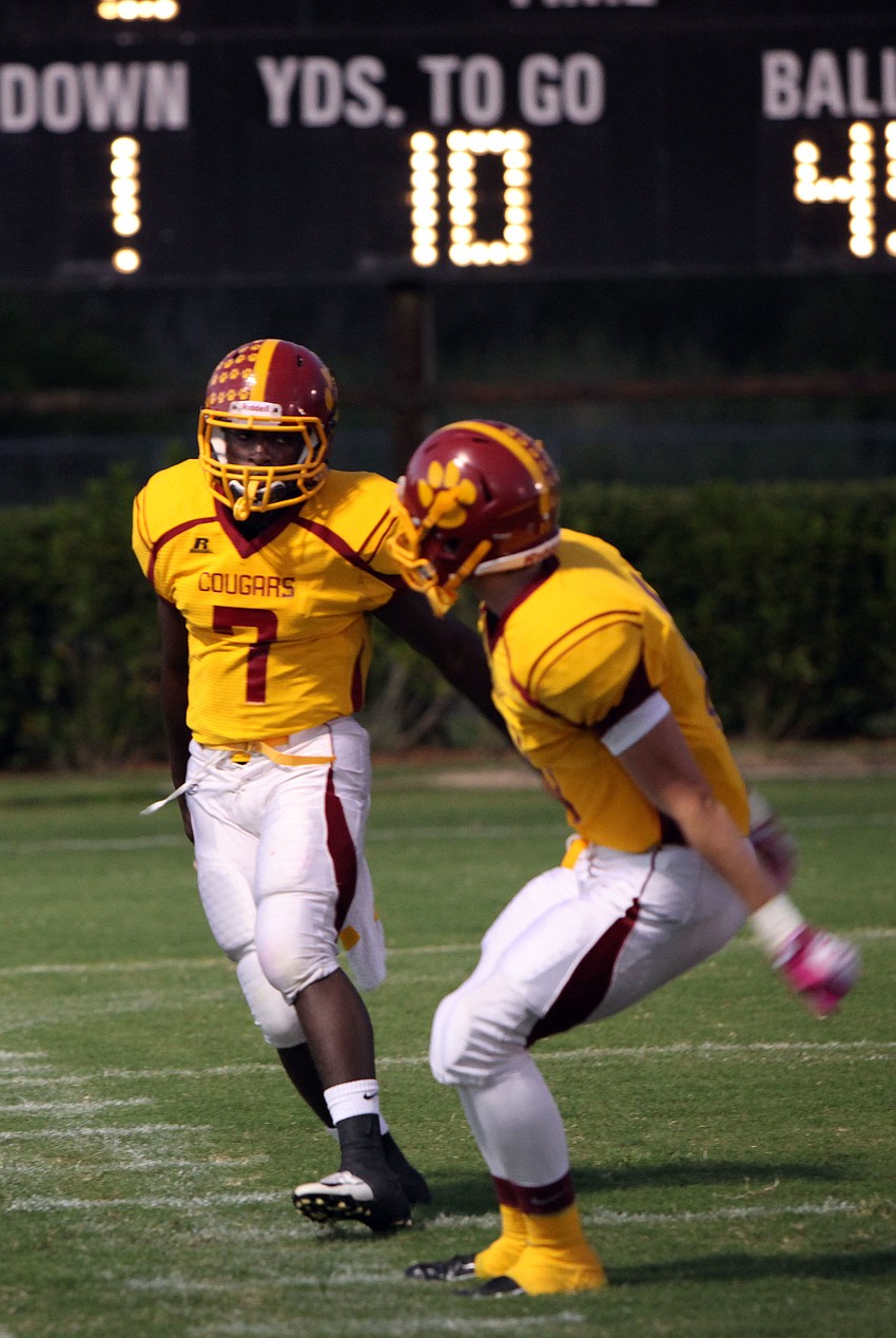 Demardre Patterson, No. 7, is congratulated by fellow teammate Casey Gunderson, No. 11, after Patterson scored the first touchdown for Cardinal Mooney during their homecoming game Friday, Oct. 12.