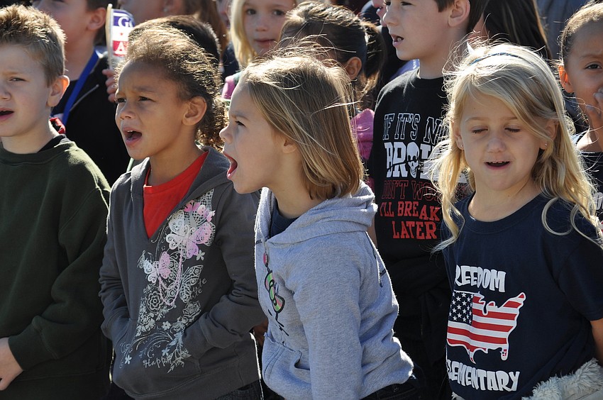 Children sang after the flag-raising ceremony at Freedom.