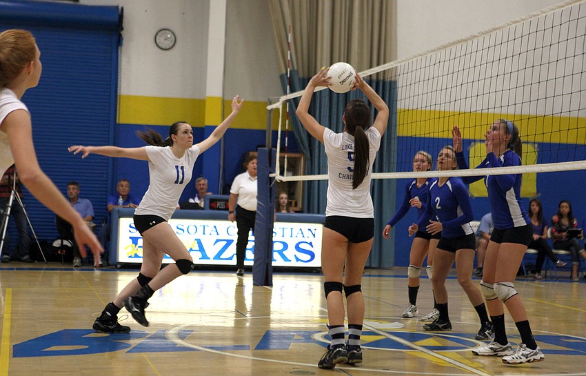 Elizabeth Owens, No. 11, rushes up to spike the ball set by teammate Amanda King, No. 5.
