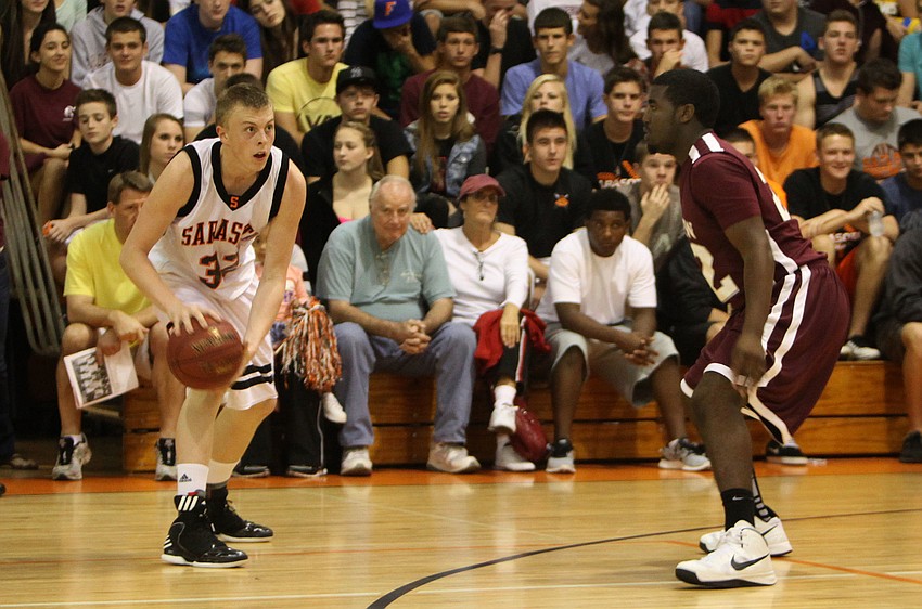 Sarasotaâ€™s Zack Rowden, No. 32, looks to see who he can pass the ball to as Riverviewâ€™s Jeremiah Henderson, No. 22, stays close.