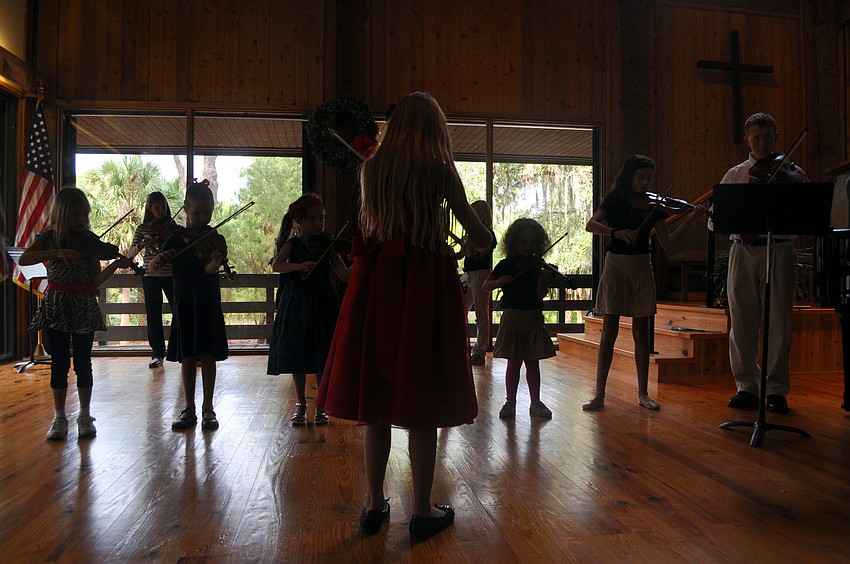 Chelsea Ball leads the Suzuki Violin Players during â€œJingle Bellsâ€.