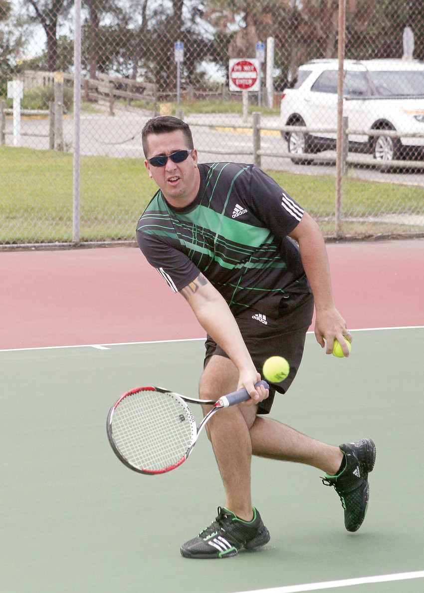 Jason Nadell goes for the ball, Aug. 29, while playing tennis with Ross Galbraith at the tennis courts by Siesta Key Public Beach.