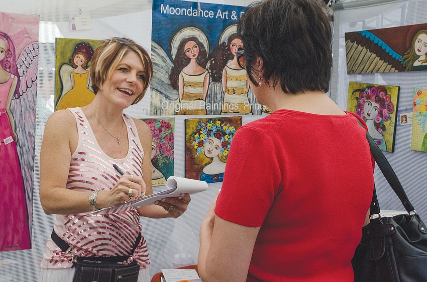 Tonya Smith speaks with festival-goers about her angel-inspired artwork from Moondance Art and Design Co., Oct. 20 at the Sarasota Art and Craft Festival.