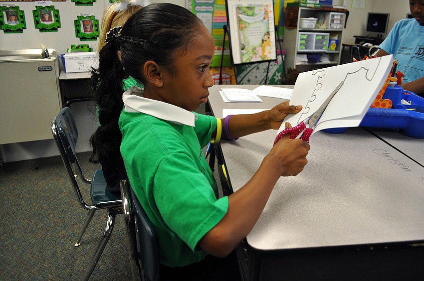 Christin Roberts works on cutting out her menorah.
