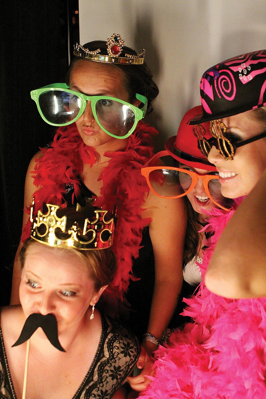Rachael Krotec, Lauren Litchet, Jessica Lake and Nicole Vesely pose with funny props inside the photo booth at Sarasota High Schoolâ€™s prom at the Hyatt Regency.