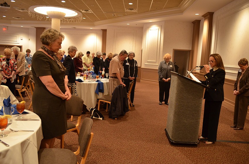 Linda Long leads the group in prayer before their meal.