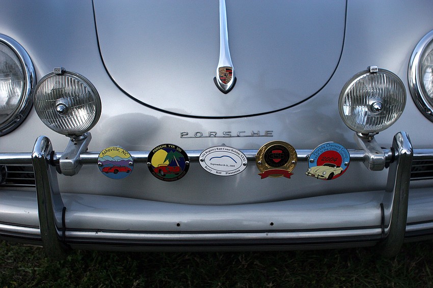 The front of Tom Holzerâ€™s 1959 356 A is decorated with a bunch of Porsche and car related medallions.
